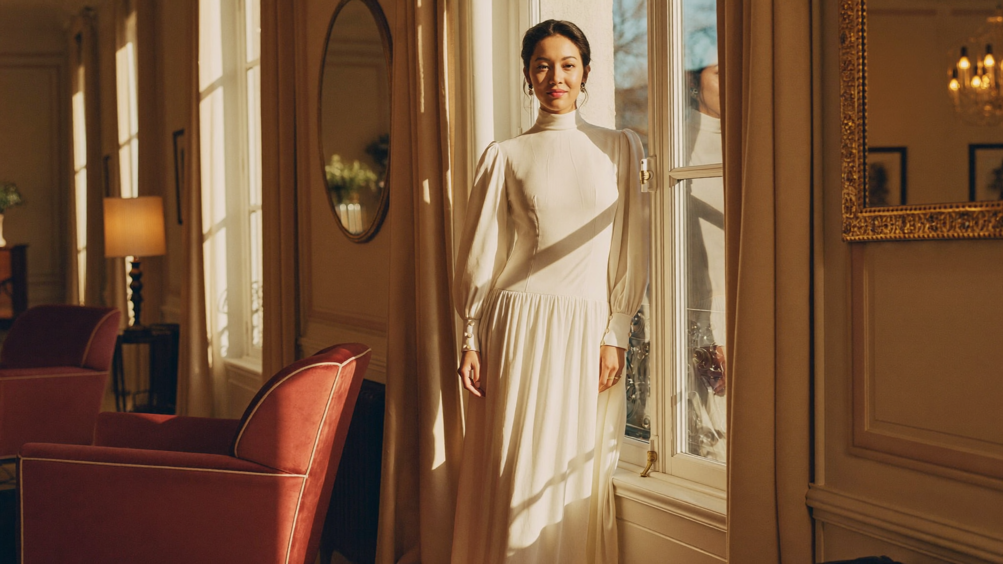 A poised, at-ease woman by a window in warm light, content with a decision made clearly