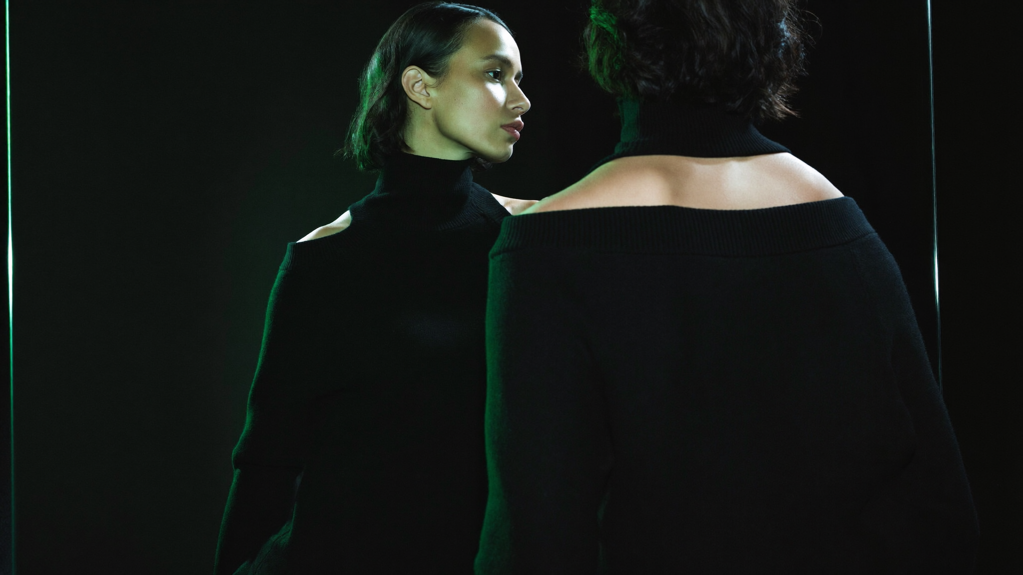 A confident woman looking thoughtfully at her own reflection, deciding on her own terms